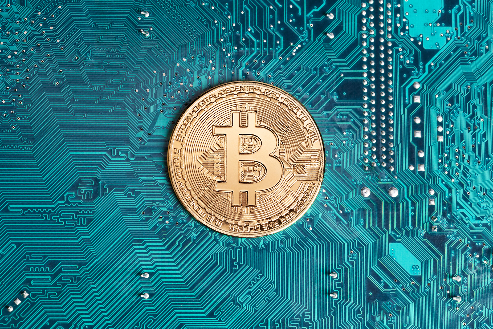 Golden bitcoin replica on computer circuit board